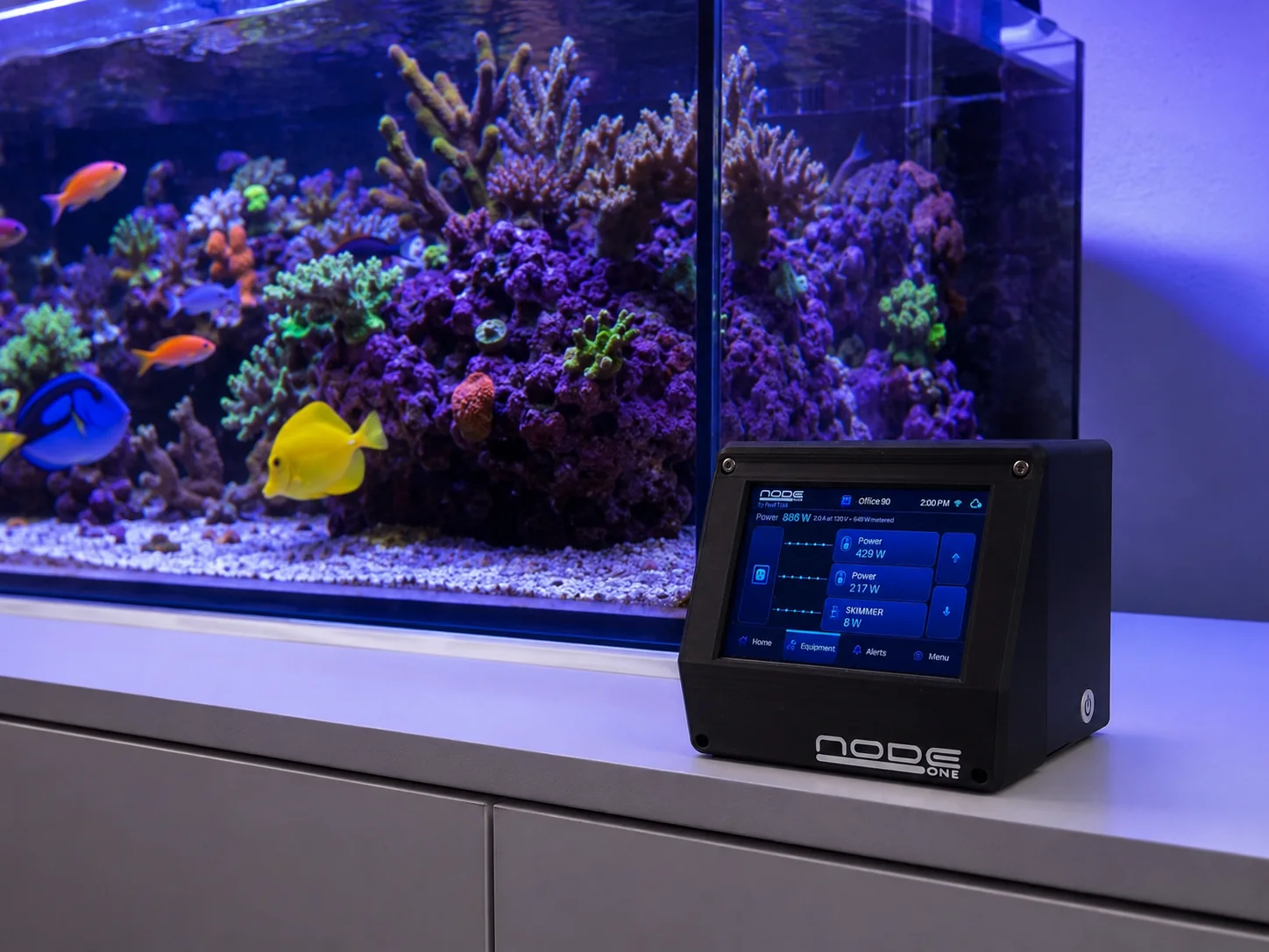 Node ONE prototype appliance sitting beside a reef aquarium with its local dashboard visible